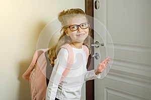 Cute junior schoolgirl with blond hair going to school, standing