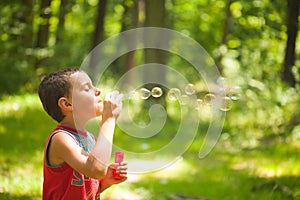 Cute kid blowing soap bubbles