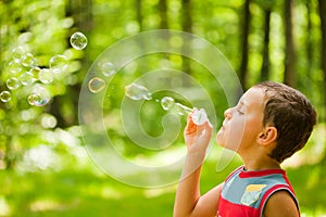 Cute kid blowing soap bubbles