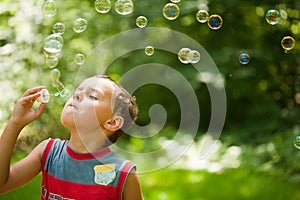 Cute kid blowing soap bubbles