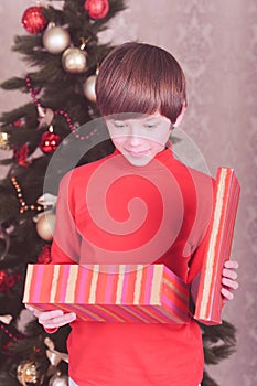 Cute kid boy open christmas gift in room