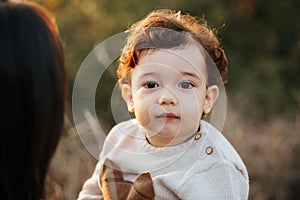 Cute kid boy is posing in the forest, thinking about something