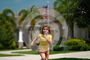 Cute kid boy running across american neighborhood street. Summer, childhood, leisure and people concept. Happy little