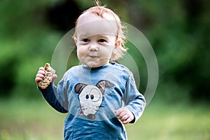 Cute kid eating bread outdoors