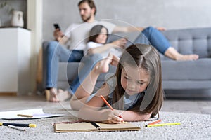 Cute kid girl playing on floor, preschool little girl drawing with colored pencils on paper spending time with family