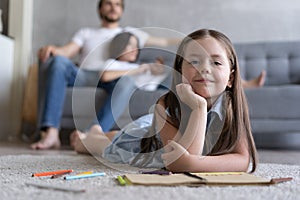 Cute kid girl playing on floor, preschool little girl drawing with colored pencils on paper spending time with family