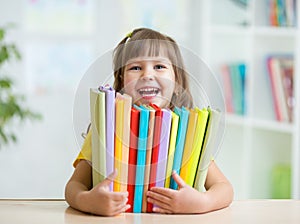 Cute kid girl preschooler with books indoor