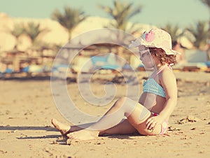 Cute kid girl sunbathing on beach