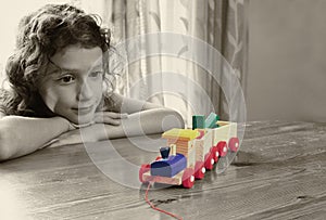 Cute kid looking at old wooden train. selective color style, and selective focus. insparation and chilhood concept