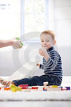 Cute kid packing toys to plastic bag