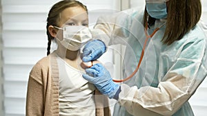 Cute kid patient visiting female doctor pediatrician nurse holding stethoscope examining happy little child girl doing