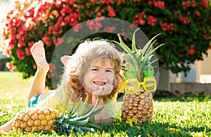 Cute kid with pineapple. Fresh tropical fruits for kids. Healthy lifestyle with fresh organic fruits.