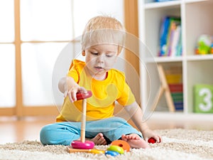 Cute kid playing with color toy indoor