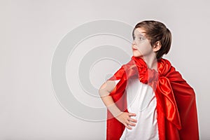 Cute kid pretend superwoman in studio