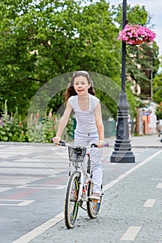 Cute kid in safety helmet biking outdoors. Little girl on a red bicycle Healthy preschool children summer activity.