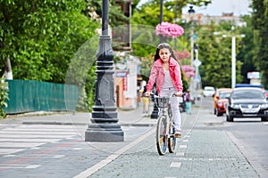 Cute kid in safety helmet biking outdoors. Little girl on a red bicycle Healthy preschool children summer activity.