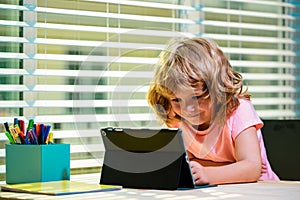 Cute kid in virtual class. School at home. Homeschool little boy student learning virtual internet online class from