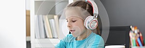 Cute kid wearing headset and typing on keyboard with effort