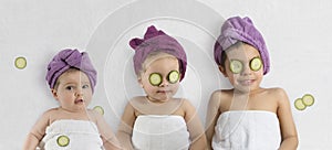 Cute kids with bath turbans and cucumbers photo