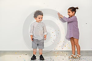 Cute kids enjoying a holiday and throwing confetti.
