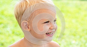 Cute kids face. Closeup portrait of smiling child boy on green background. Kid smile. Emotion concept.