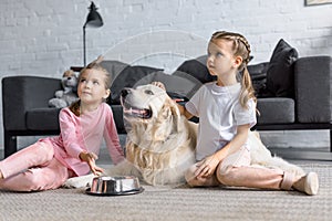 cute kids with golden retriever dog sitting on floor