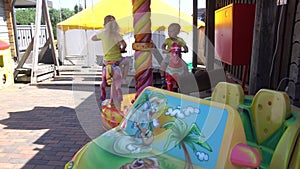 Cute kids have fun sitting on carousel. Gimbal motion