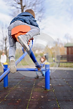 Cute kids having fun on seesaw at playground