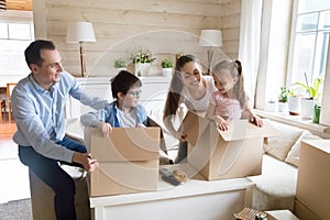 Cute kids hide in cardboard boxes playing during unpacking