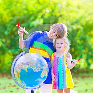 Cute kids playing with airplanes and globe