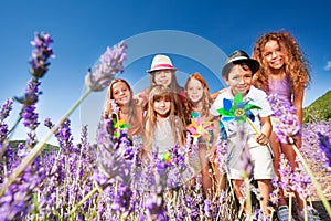 Cute kids playing with pinwheels in lavender field
