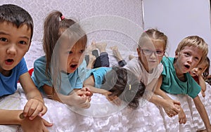 Cute kids singing on sofa at home