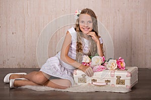 Cute lady girl with blond hairs pink cheeks and blue eyes posing sit for camera in studio wearing airy white dress and fancy casua