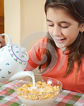 Cute latin girl eating breakfast at home