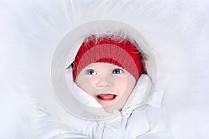 Cute laughing baby with blue eyes in snow suit