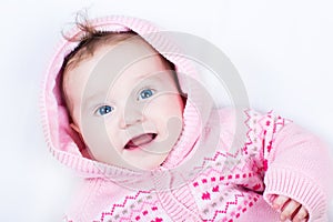 Cute laughing baby with blue eyes in snow suit