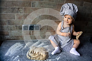 Cute laughing baby girl in a cook suit