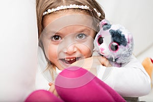 Cute laughing little girl with her fluffy toy