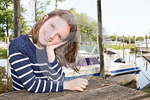 Cute liitle girl close-up during vacation near lake river and boat