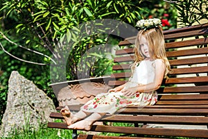 Cute litle barefoot girl sitting on the bench