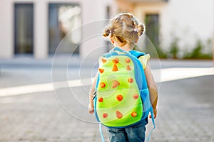 Cute little adorable toddler girl on her first day going to playschool. Healthy beautiful baby walking to nursery school