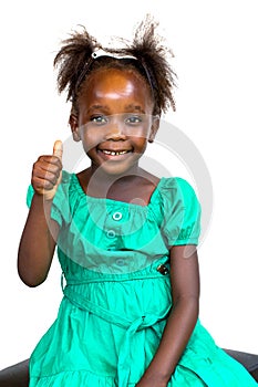 Cute little African girl in green dress doing thumbs up