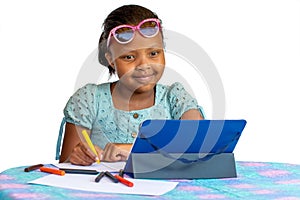 Cute little african kid looking at tablet while drawing