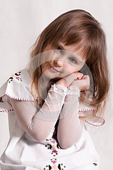 Cute,little angel with beautiful blue eyes in white dress