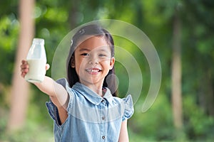 Cute little asia girl is drinking milk in bottle