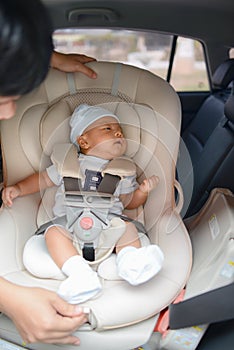 Cute little Asian baby boy sitting on Carseat
