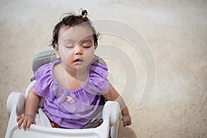 Cute little asian baby girl Sitting asleep on dining table After eating full in the house