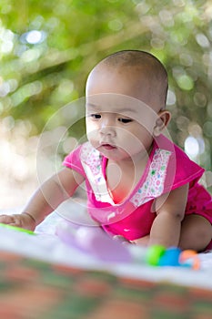 Cute little Asian baby sitting and play with happiness