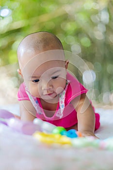 Cute little Asian baby sitting and play with happiness