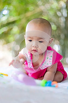 Cute little Asian baby sitting and play with happiness